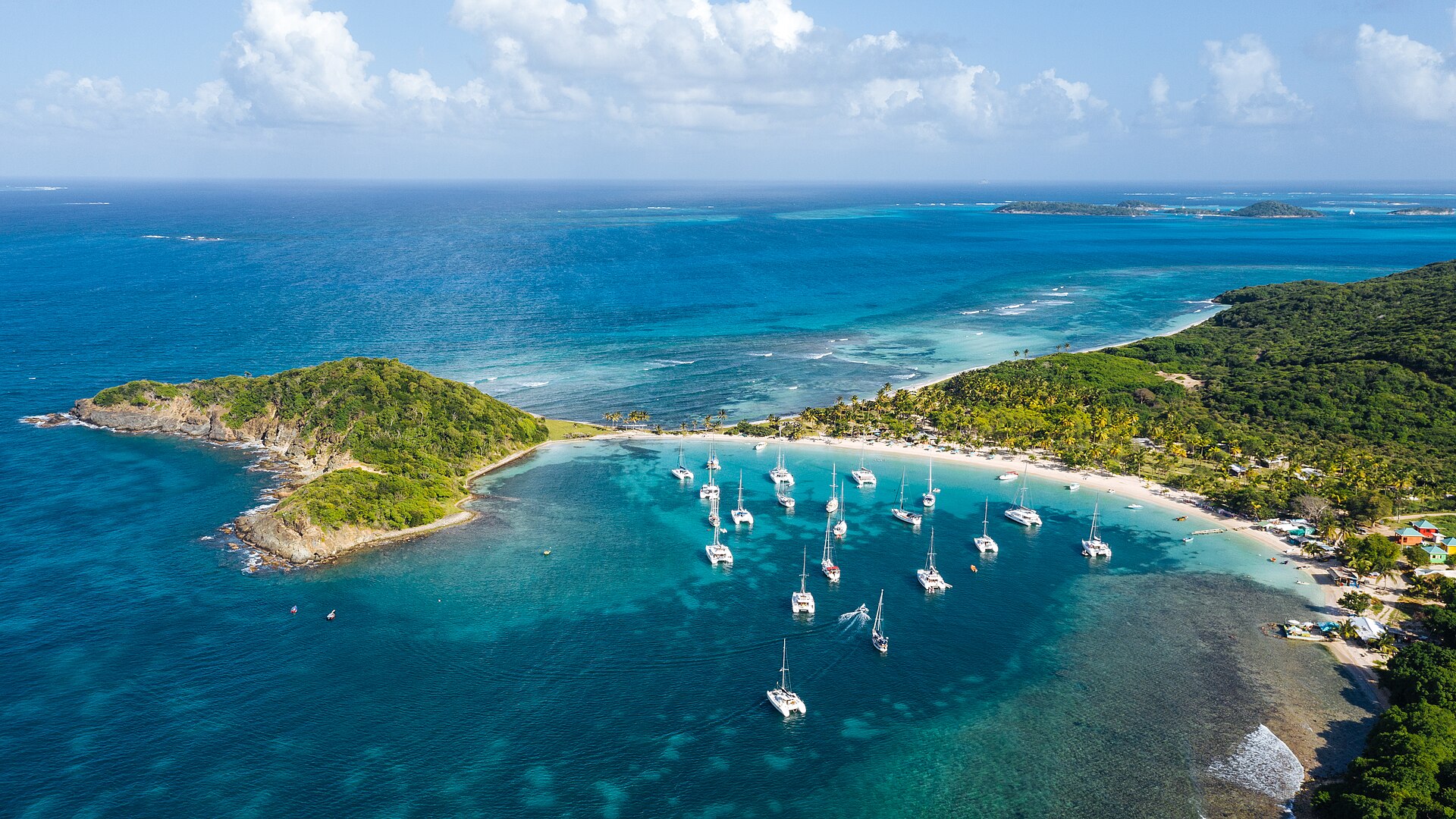 Aerial photograph of the crescent beach and boats anchored at Salt Whistle Bay, Mayreau