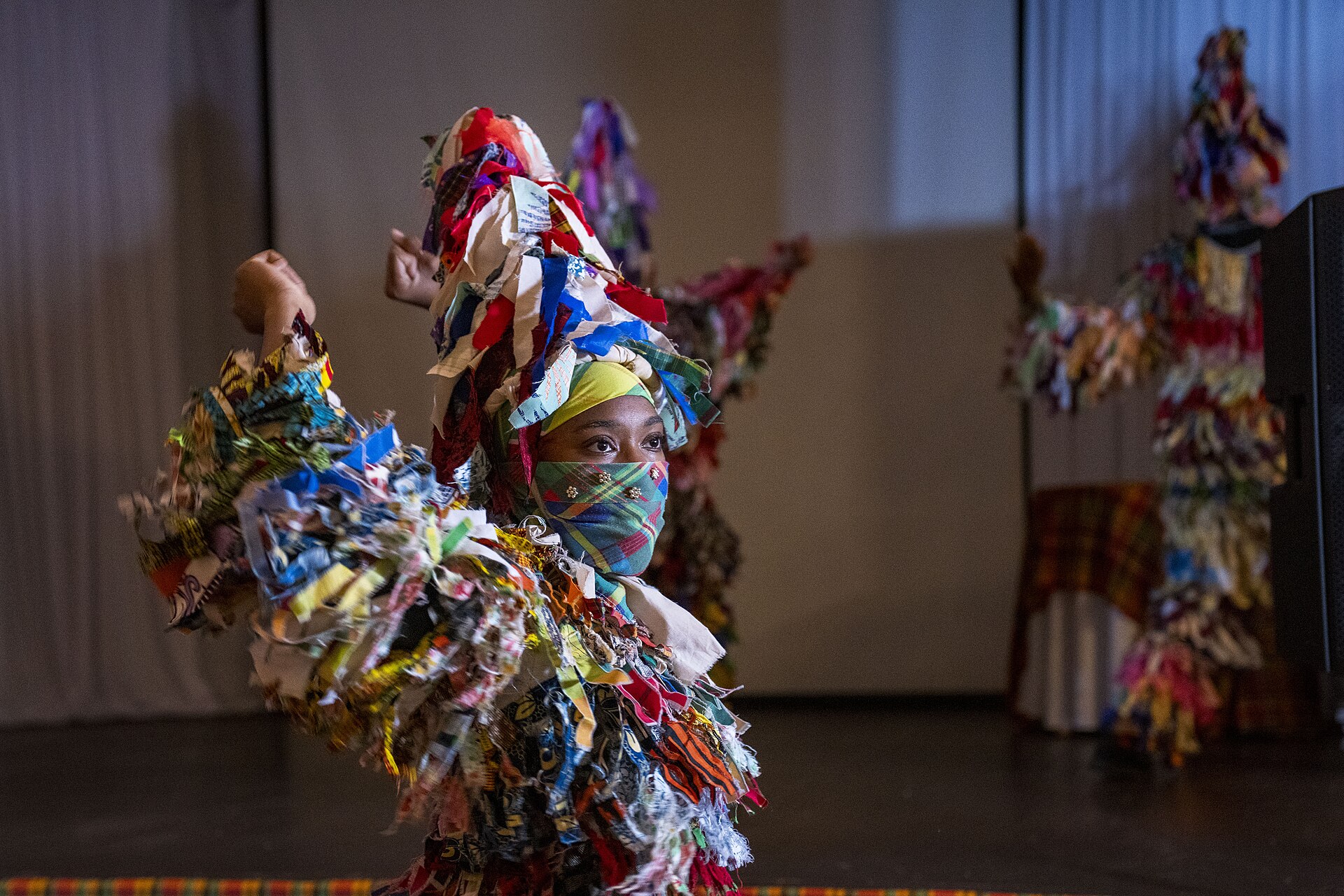 A Saint Lucian performer in traditional rag-and-madras costume mid-dance