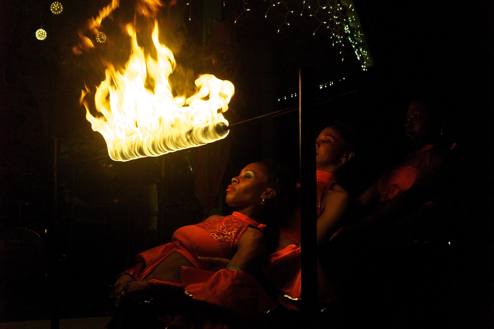 Fire dancers with a limbo pole performing at night in Saint Lucia